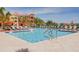 Community pool with ample lounge chairs, palm trees, and views of a hotel-like building at 2722 Via Tivoli # 430A, Clearwater, FL 33764