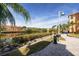 Scenic waterfront view with manicured landscaping, a paved walkway, and colorful buildings on the opposite bank at 2722 Via Tivoli # 430A, Clearwater, FL 33764