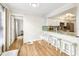Eat-in kitchen featuring a breakfast bar, hardwood floors and white cabinets at 2969 Bonaventure Cir # 104, Palm Harbor, FL 34684