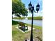 Scenic pond view with a bench and vintage street lamp, perfect for relaxing by the water at 2969 Bonaventure Cir # 104, Palm Harbor, FL 34684