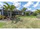 Well-maintained backyard with green lawn, palm trees, and view of the screened in patio at 3166 Francoa Dr, Odessa, FL 33556