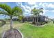 Manicured backyard featuring mature palm trees, lush landscaping, and a screened-in lanai at 3166 Francoa Dr, Odessa, FL 33556