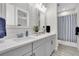 Elegant bathroom featuring double sinks, modern fixtures, and a shower with blue striped curtain at 3166 Francoa Dr, Odessa, FL 33556