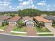 Charming single-story home featuring a tile roof, gray exterior paint, complemented by a well-manicured lawn and mature trees at 3166 Francoa Dr, Odessa, FL 33556