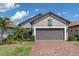 Charming home featuring a brick driveway, lush landscaping, and a two-car garage at 3166 Francoa Dr, Odessa, FL 33556