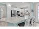 Well-lit kitchen features white cabinets, stainless steel appliances, a quartz countertop island, and wood-look flooring at 3166 Francoa Dr, Odessa, FL 33556