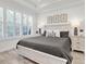 Cozy bedroom featuring a king-size bed, wood-look floors, shuttered windows, and tasteful decor at 3166 Francoa Dr, Odessa, FL 33556