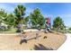 Community playground with slide, see-saw, and climbing structure surrounded by lush trees at 3166 Francoa Dr, Odessa, FL 33556