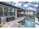 Enclosed patio with a beautiful pool, lounging area, and access to indoor living space at 3166 Francoa Dr, Odessa, FL 33556