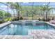 Inviting screened pool with waterfall feature, lush landscaping, and scenic backyard view at 3166 Francoa Dr, Odessa, FL 33556