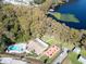 Aerial shot of community lakeside amenities with a pool, picnic area, and wooded shoreline at 3224 Hilary Cir, Palm Harbor, FL 34684