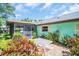 Outdoor patio with lush landscaping, a table, and a view of the home's screened patio at 3224 Hilary Cir, Palm Harbor, FL 34684
