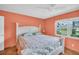 Bedroom with coral walls, tile floors, a ceiling fan and a large window with a view of the yard at 3224 Hilary Cir, Palm Harbor, FL 34684