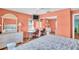 Bedroom with coral walls, a white dresser, desk, and office chairs and a large window with blinds at 3224 Hilary Cir, Palm Harbor, FL 34684