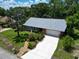 Charming home with a concrete driveway, a white garage door, and a landscaped yard at 3224 Hilary Cir, Palm Harbor, FL 34684
