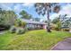 Charming single-story brick home with well-manicured lawn and tropical landscaping at 3224 Hilary Cir, Palm Harbor, FL 34684