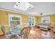 Bright living room with tile floors, skylight, ceiling fan and glass table with wicker chairs at 3224 Hilary Cir, Palm Harbor, FL 34684