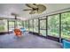 Enclosed sunroom with multiple ceiling fans, patio furniture, and views of the landscaped backyard at 3224 Hilary Cir, Palm Harbor, FL 34684