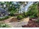A lush backyard features a walkway, a bench, screened enclosure, and mature trees at 3406 Hollyhock Way, Tampa, FL 33618