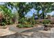 Charming backyard with a circular garden bed, paver patio, and mature trees, offering a serene and private outdoor retreat at 3406 Hollyhock Way, Tampa, FL 33618