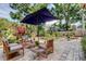 Backyard patio space featuring a large umbrella, patio furniture, landscaping, and privacy fence at 3406 Hollyhock Way, Tampa, FL 33618