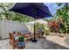 Relaxing backyard patio space featuring a large umbrella, patio furniture, and potted plants at 3406 Hollyhock Way, Tampa, FL 33618