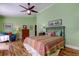 Comfortable bedroom features a ceiling fan, colorful bedspread, and soothing green walls at 3406 Hollyhock Way, Tampa, FL 33618