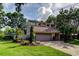 Two-story home showcasing meticulous landscaping, mature trees, and a charming, brick-paved driveway and two-car garage at 3406 Hollyhock Way, Tampa, FL 33618