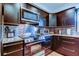 Sleek kitchen features dark cabinets, stainless steel appliances, and a tiled backsplash at 3406 Hollyhock Way, Tampa, FL 33618