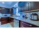 Modern kitchen featuring dark cabinetry, stainless steel appliances, and granite countertops at 3406 Hollyhock Way, Tampa, FL 33618