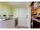 Convenient laundry room with washer, dryer, storage shelves, and a neatly organized space at 3406 Hollyhock Way, Tampa, FL 33618
