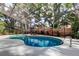 Private pool within a screened enclosure, bordered by lush landscaping and a wooden fence at 3406 Hollyhock Way, Tampa, FL 33618