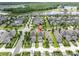 Aerial view of a neighborhood showcasing well-maintained homes and tree-lined streets near a lake at 3757 Villamore Ln, Odessa, FL 33556