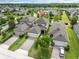 Aerial view of home in a suburban neighborhood with well-manicured lawns and a mature tree canopy at 3757 Villamore Ln, Odessa, FL 33556