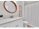 Bright bathroom featuring white cabinets, light countertops, a round mirror, and shower with white curtain at 3757 Villamore Ln, Odessa, FL 33556