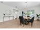 Dining room with a wooden table, upholstered chairs, pendant lighting, and a large window at 3757 Villamore Ln, Odessa, FL 33556