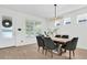 Dining room with a modern chandelier, wood floors, and a large window providing natural light at 3757 Villamore Ln, Odessa, FL 33556