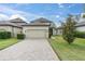 Two-story house with a two car garage, brick driveway, well-maintained lawn and a mature tree at 3757 Villamore Ln, Odessa, FL 33556