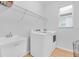 Laundry room with front loading washer and dryer, utility sink, metal shelving, and tile floors at 3757 Villamore Ln, Odessa, FL 33556