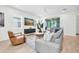 Bright living room with a gray sofa, accent chair, large windows, and a sliding glass door at 3757 Villamore Ln, Odessa, FL 33556