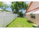 Side yard featuring lush green grass and a white fence line at 39055 9Th Ave, Zephyrhills, FL 33542