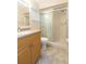Bathroom features a shower with sliding glass doors and a single sink with wood cabinets at 39055 9Th Ave, Zephyrhills, FL 33542