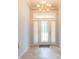 Elegant foyer with decorative tile flooring, a chandelier, and a beveled glass front door at 39055 9Th Ave, Zephyrhills, FL 33542