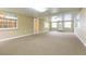 Spacious, brightly lit living room offering access to multiple doors and windows at 39055 9Th Ave, Zephyrhills, FL 33542