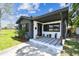 Charming home entrance with a covered porch, stone accents, stylish tiling, and lovely potted plants at 400 83Rd Ne Ave, St Petersburg, FL 33702