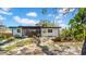 Backyard view of the house featuring garden beds, mature trees, and the home's exterior with glass sliding doors at 4642 29Th N Ave, St Petersburg, FL 33713