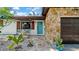Charming home featuring a unique stone facade, a vibrant turquoise door, and a cozy seating area at 4642 29Th N Ave, St Petersburg, FL 33713