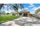 Attractive home featuring a green lawn, mature trees, a driveway, and a unique stone facade on the attached garage at 4642 29Th N Ave, St Petersburg, FL 33713