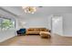 Cozy living room showcasing laminate flooring, a comfortable brown sofa, and large windows for natural light at 4642 29Th N Ave, St Petersburg, FL 33713