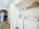 Bright laundry room with side by side washer and dryer and overhead storage at 4732 Ashburn Pond Way, Tampa, FL 33610